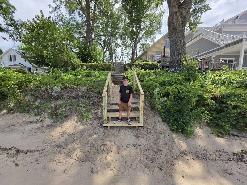 Newly rebuilt wooden beach stairs and handrails leading down the dune to Silver Beach